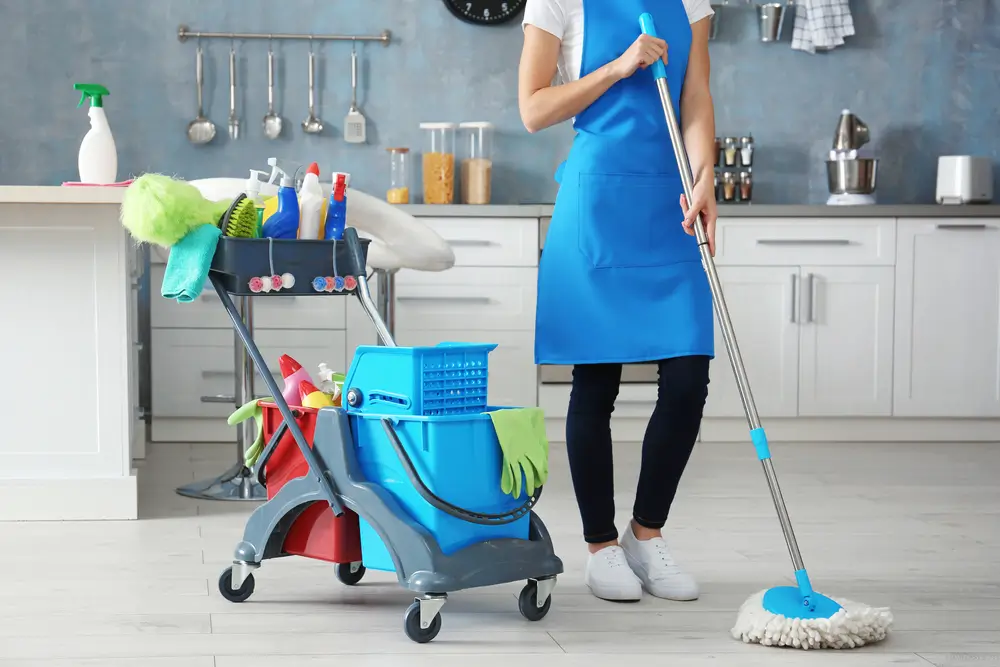 Kobieta z akcesoriami do sprzątania w domu